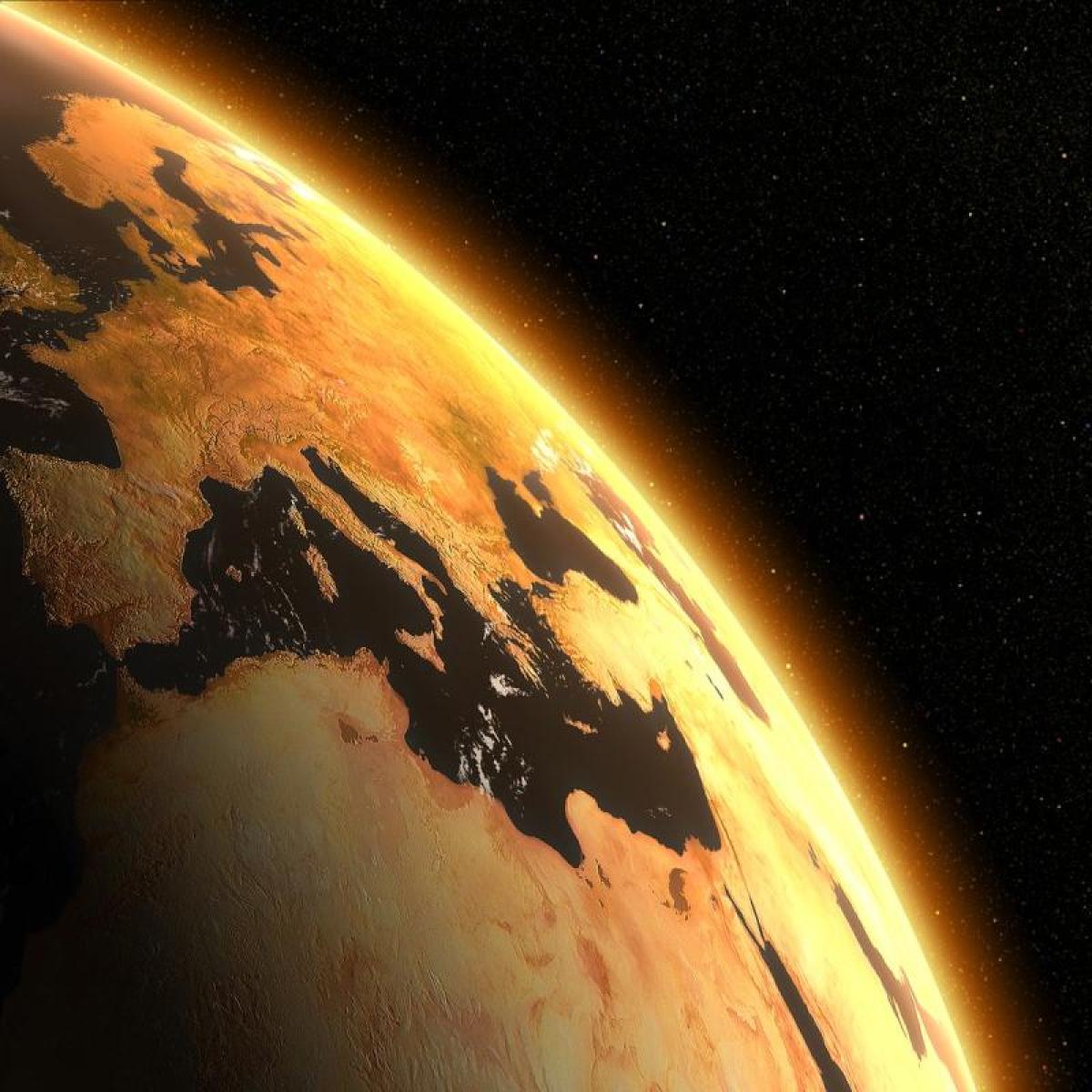 the Earth in profile as the sun rises from around it in space
